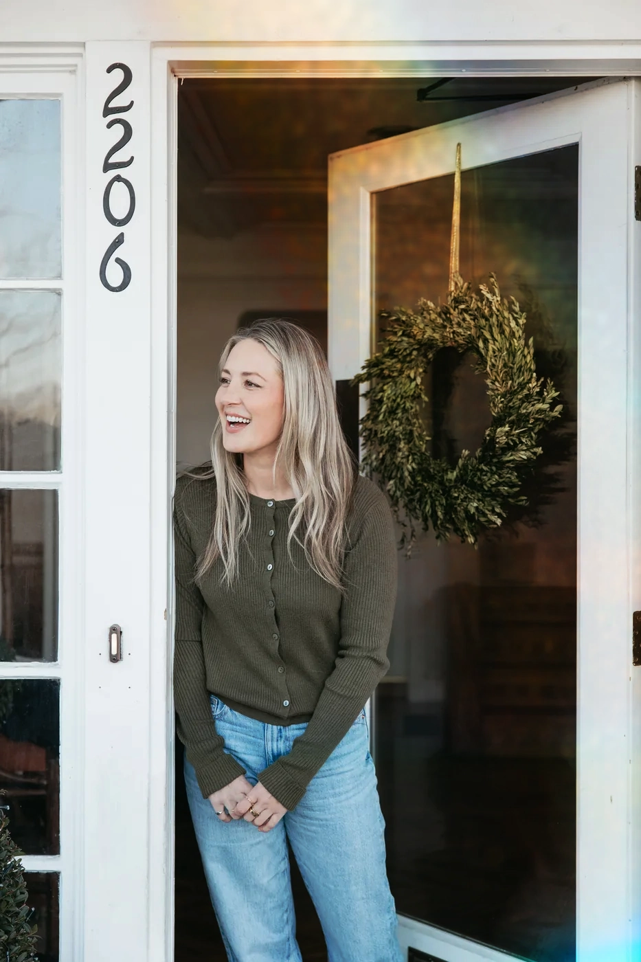 A woman smiling warmly in a doorway, welcoming you to True You Therapy and Wellness in Oregon